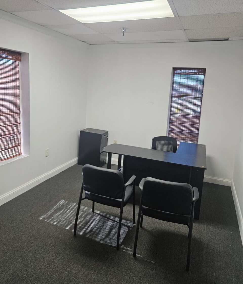 Furnished private office suite with a desk and guest chairs.